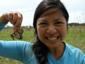 A self-portrait of the author holding a monarch butterfly